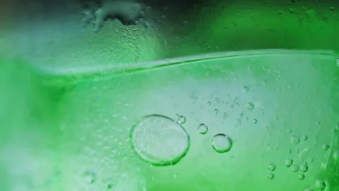 Bubbles of carbonated green lemonade with ice cubes in a glass. Stock Footage 314833810