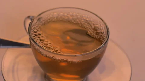 The bubbles in a clear glass are formed by pouring tea into a glass Stock Footage 138263779
