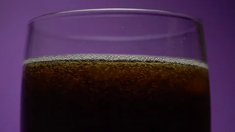 Bubbles of a cola in the glass with ice. Spinning slow motion Stock Footage 85864893