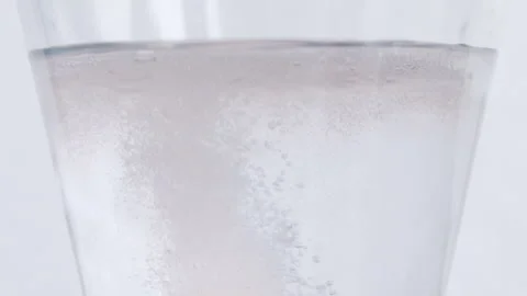 Bubbles from an efffervescent dissolving in a glass of water Stock Footage 273123558