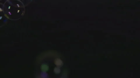 Bubbles fall down on black surface and burst in slow motion Stock Footage 58761230