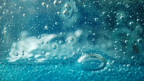 Bubbles fall in slow motion in blue fluid, liquid dish soap macro Stock Footage 112529058