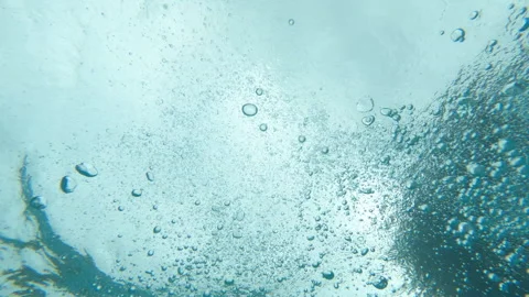 Bubbles float up and away from camera as we look up at the surface, slow motion Stock Footage 248079751