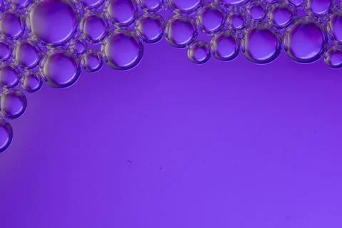 Bubbles float on a purple surface. Stock Photos