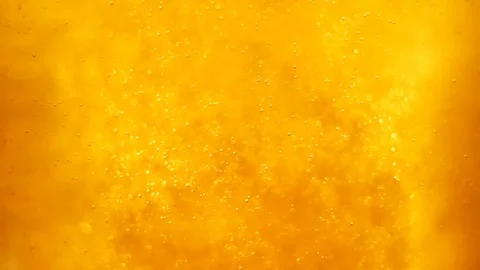 Bubbles floating in the amazing deep structured yellow gold liquid. Stock Footage 79834496