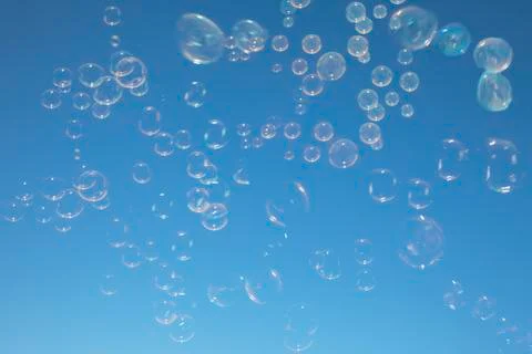 Bubbles floating in blue sky Foto stock