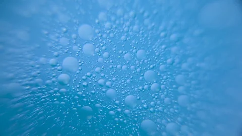 Bubbles floating on blue water Stock Footage 76102825
