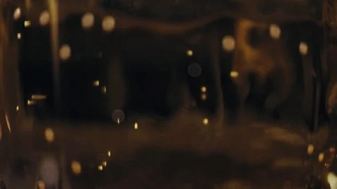 Bubbles floating in a cider or beer. Dark background with bokeh Stock Footage 89308644