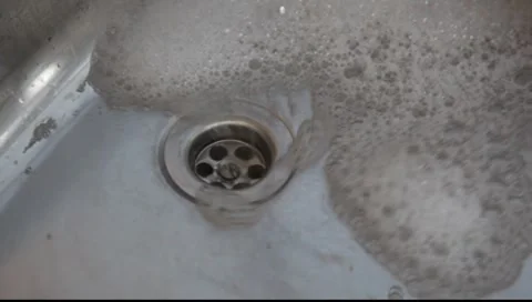 Bubbles flowing down plog hole. Stock-Footage 7744152