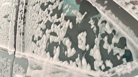 Bubbles form as soap foam and water interact on a dirty surface during a Stock Footage 339005322