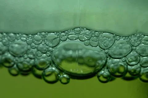 Bubbles form on the surface of a green liquid, possibly indicating a chemical 스톡 사진