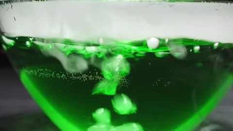 Bubbles of gas in boiling green liquid on a black background. 스톡 동영상 122014495