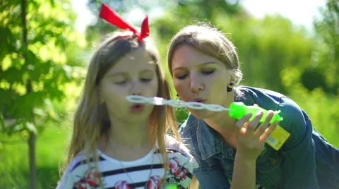 Bubbles, mom playing with her daughter Stock Footage 64344538