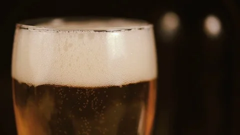 Bubbles movement inside a large glass mug with fresh beer Stockbeeldmateriaal 75655473