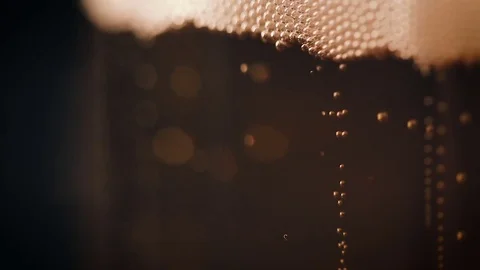 Bubbles movement inside a large glass mug with fresh beer Видео 75660347