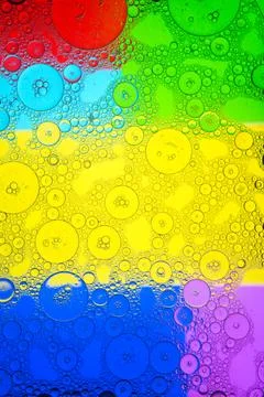 Bubbles on multicolored geometric background Stock Photos