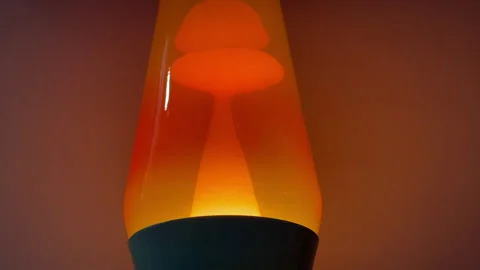 Bubbles of orange liquid moving in a lit up motion lamp close up Stock Footage 328880878