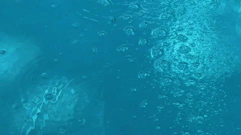 Bubbles percolate and rise to the surface in blue pool water Stock Footage 231181212