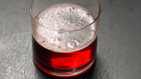 Bubbles Pop in Slow Motion in Filled Cup of Soda on Black Background Video stock 117113371