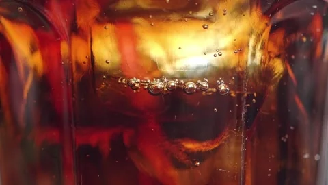 Bubbles rise in a glass of dark beverage captured close up Stock Footage 345187750