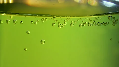 Bubbles rise slowly forming patterns within a bright liquid surface Stock Footage 331726216