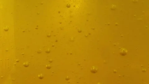 Bubbles rise slowly on a yellow background Stock Footage 137434928