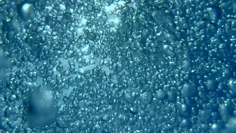 Bubbles rise to the surface as sunlight filters through water in summer pool Stock-Footage 337016629