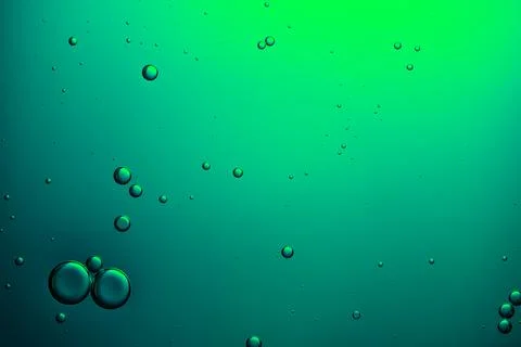 Bubbles rising in abstract green liquid background Stock Photos
