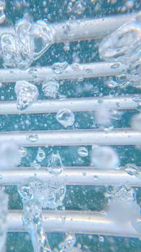 Bubbles rising around metal pool ladder underwater in turquoise water Stock Footage 342156659