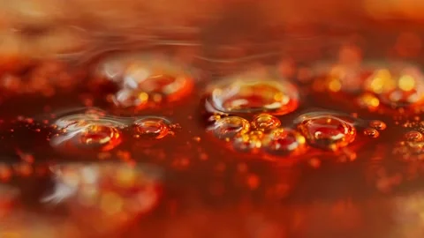 Bubbles rising in boiling thick, amber-brown liquid making an abstract Vidéo 138531426