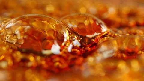 Bubbles rising in boiling thick, amber-brown liquid making an abstract Vidéo 146284293