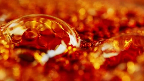 Bubbles rising in boiling thick, amber-brown liquid making an abstract Vidéo 153306708