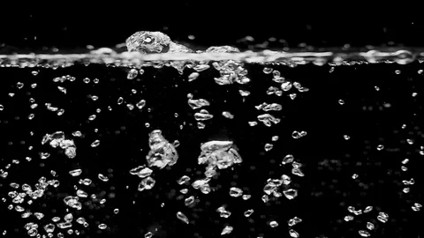 Bubbles rising up. Boiling water, closeup. Isolated black background. Shot on Stock Footage