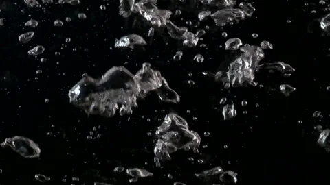 Bubbles rising up. Boiling water, closeup. Isolated black background. Stock Footage 221484753