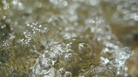 Bubbles swirl on the water of a mountain stream (slow motion, bokeh) Video stock 219640188