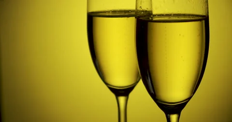 Bubbles in two glasses of champagne on yellow background. Stock Footage 141774231
