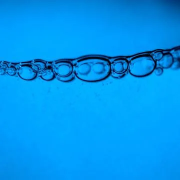 Bubbles under water on blue background. Stock Photos