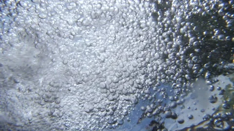 Bubbles in water flowing. Shot from underneath the surface in water. Underwater Stock Footage 156544026