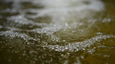 Bubbles on water in a pool  of a mountain river (slow motion, bokeh) Video stock 212751482