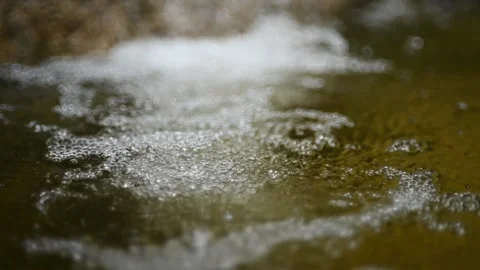 Bubbles on water in a pool  of a mountain river (slow motion, bokeh) Video stock 212751537