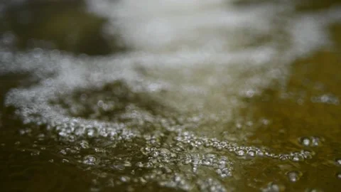 Bubbles on water in a pool  of a mountain river (slow motion, bokeh) Video stock 212752243