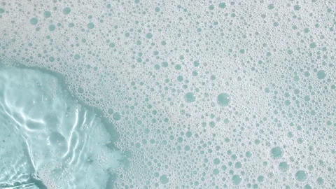 Bubbles of white soap foam on a blue background. Bathtup Soap Foam. Texture of Video stock 255676602