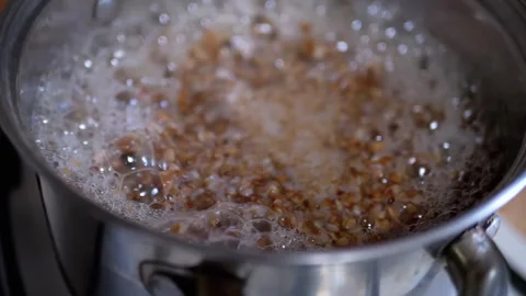 A Bubbling Pot Full of Cooking Grains or Pulses Gently Heating and Simmering to Stock Footage 312014709