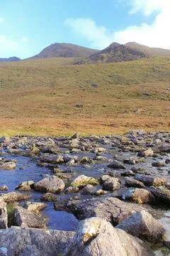 A   bubbling   river   in   front   of   rolling   hills Stock Photos