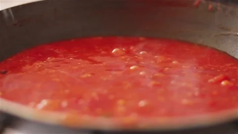 Bubbling tomato sauce in pan close up cooking process Stock Footage 116551072