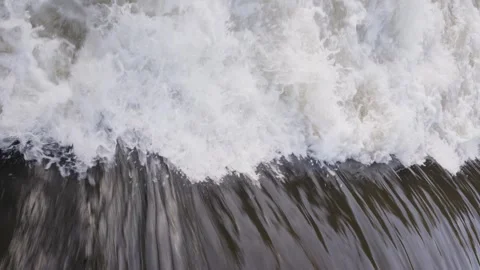 Bubbling water cascading down a river forming white foam Video stock 297856637