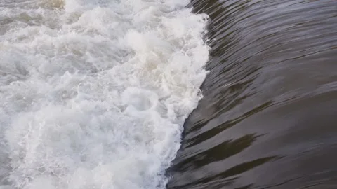 Bubbling water cascading down a river forming white foam Видео 297856638