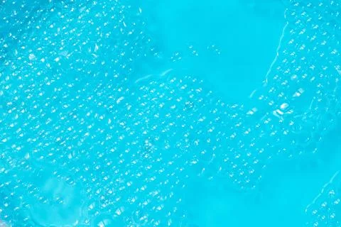 Bubbly Aqua. Close-up of clear bubbles floating on a vibrant blue water Stock Photos