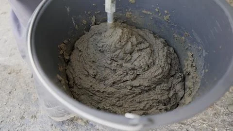 Bucket close up. A worker mixes a solution in a bucket with a construction mi Stock Photos
