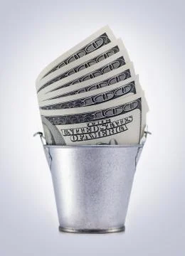 Bucket with dollars Stock Photos